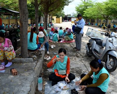 Garment workers have lunch outside their factory in Phnom Penh on April 3, 2025. Southeast Asian countries with a significant trade surplus with the United States came in for harsh treatment, with Vietnam being hit with a 46 percent levy and Cambodia 49 percent. (Photo by TANG CHHIN Sothy / AFP)