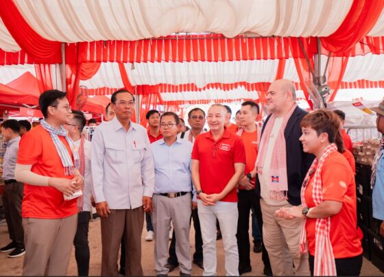 Paulo Gaspar Rodrigues, CEO of Coca-Cola Cambodia Beverage Company, and Charlie Bettencourt, Managing Director of DFI Lucky Private Limited, join H.E. Sreng Hong, Deputy Governor of Battambang Provincial Administration, and H.E. Khlok Noay, Deputy Governor of Banteay Meanchey Provincial Administration, alongside community members including beneficiaries Sla Mat and Uch Pheap, during the Zero Riel Market initiative held in Battambang and Banteay Meanchey ahead of Khmer New Year 2026.